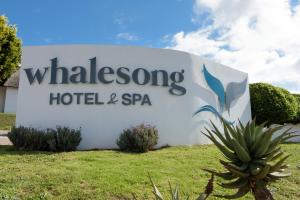 普利登堡湾Whalesong Hotel & Spa的鲸鱼酒店和水疗中心的标志