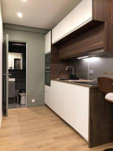 巴黎Studio design proche Champs-Elysées的厨房配有白色和棕色橱柜和水槽