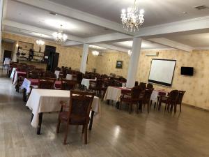 敖德萨海军上将酒店的一间带桌椅和屏幕的用餐室