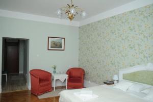 奥拉迪亚Sophie Apartment的一间卧室配有两张红色椅子和一张床