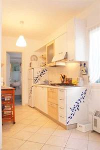 圣温琴佐Appartamento Pergola的厨房配有白色橱柜和白色冰箱。