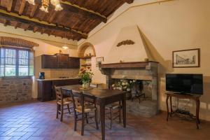 科尔托纳艾尔格索酒店的厨房配有桌子和壁炉