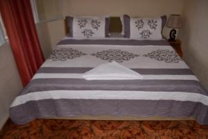 吉塞尼Musanto Hotel的一间卧室配有一张铺有紫色和白色床单的床