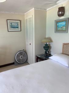布里奇敦Beach Vue Barbados的卧室配有白色的床和风扇