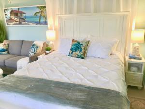 那不勒斯Coastal Studio Escape!的一张大白色的床,位于一个配有沙发的房间