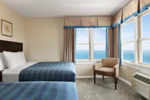大洋城哈里森豪酒店的酒店客房带一张床、椅子和窗户