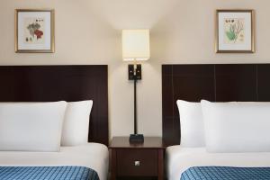 大洋城哈里森豪酒店的酒店客房,设有两张床和一盏灯