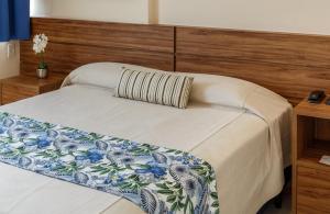 萨尔瓦多Rede Andrade Riviera Premium的一间卧室配有一张带木制床头板的床