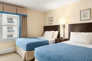 大洋城哈里森豪酒店的酒店客房设有两张床和窗户。