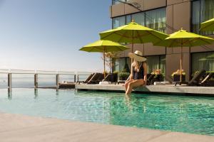 西雅图四季酒店西雅图的坐在建筑物旁边的游泳池里的女人