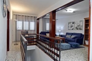弗龙特拉VIVIENDA VACACIONAL CRUZ ALTA的通往带蓝色沙发的客厅的楼梯