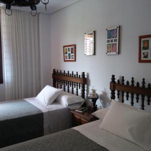 桑坦德Habitaciones en El Sardinero-Santander的一间卧室设有两张床和窗户。