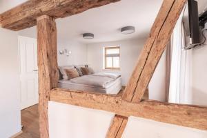 马格修希黑姆maindrei - schlafen am fluss的卧室配有一张床铺,位于带木梁的房间