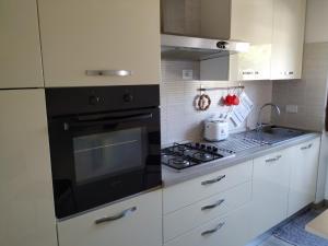费拉约港Bell'appartamento的厨房配有黑炉和白色橱柜。