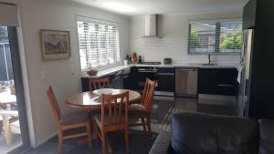 新普利茅斯Purakau Bed & Breakfast的一间带桌椅的厨房和一间带炉灶的厨房