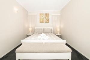 科罗曼德镇科罗曼德公寓 的白色卧室配有带两盏灯的白色床
