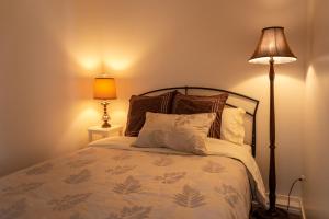 北温哥华The Secret Garden Treehouse的一间卧室配有带枕头和台灯的床