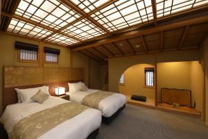 京都Gion Oyado Kikutani的一间卧室设有两张床和天窗