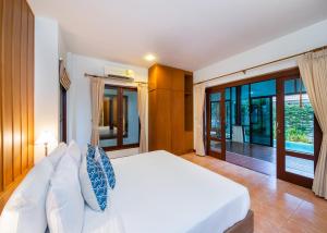 华欣藍色海洋華欣度假村及別墅的卧室配有白色的床和滑动玻璃门