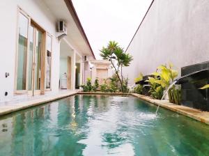 BanjarVilla Santika的房屋中间的游泳池