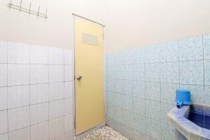 KalirejoNabhan Homestay的一间带卫生间和黄色门的浴室