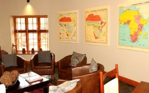 比勒陀利亚舍伍德小屋酒店的一间设有椅子和地图的等候室