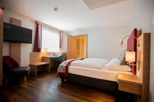 萨尔茨堡Hotel Elefant Family Business的酒店客房设有一张大床和一张书桌。