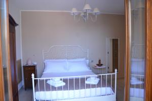 瓦拉泽B&B LE TRE FATE的一间卧室配有白色床和2个床头柜