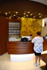 阿拉Hotel Shangri-La的站在商店现金登记册上的妇女