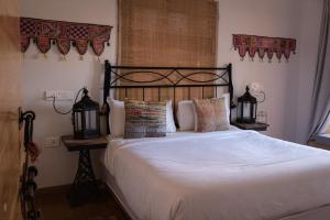 斋沙默尔秘密之家成人酒店的卧室配有一张带白色床单和枕头的大床。