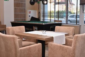 尤斯托尼莫斯基ALKA Sun Resort的一间带台球桌和椅子的用餐室