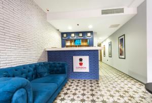 巴统Hotel London的客厅在壁炉前配有蓝色沙发