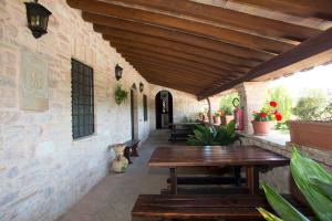 斯佩洛Terre Del Cantico Country House的户外庭院设有木桌和长凳