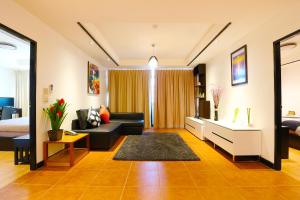曼谷沙吞塞丽娜套房公寓的客厅配有沙发和1张床