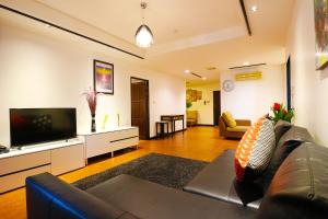 曼谷沙吞塞丽娜套房公寓的带沙发和平面电视的客厅