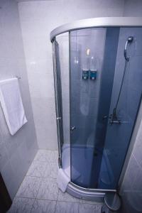 阿克套阿克塔酒店的浴室里设有玻璃门淋浴