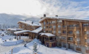 班斯科Pirin Golf Hotel & Spa的一座大木结构建筑,地面上积雪