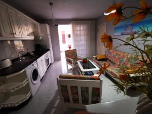 波多·纳奥斯Apartamento Candil的厨房以及带沙发和桌子的客厅。