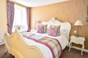 阿克斯明斯特The George Hotel的卧室配有一张带紫色枕头的大型白色床。