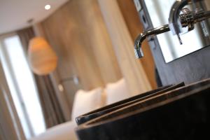 巴黎喜登酒店的沙发旁带水龙头的浴室水槽