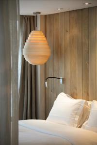 巴黎喜登酒店的一间设有一盏灯和一张四柱床的房间
