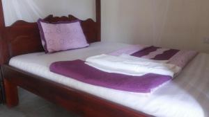 AdjumaniDubai Resort Hotel的一张带紫色和白色床单及枕头的床