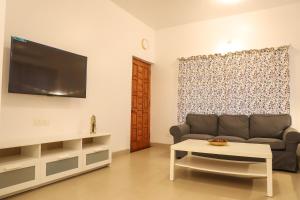 波尔沃林Surya Kiran Porvorim的带沙发和电视的客厅
