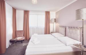 萨尔茨堡优博夫尔精品酒店的酒店客房,配有两张床和椅子