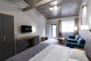 萨马拉Inter Hotel的酒店客房配有1张床、1台电视和1张沙发。