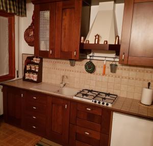 利维松多里Charme & Relax a Rivisondoli的厨房配有木制橱柜和炉灶烤箱。