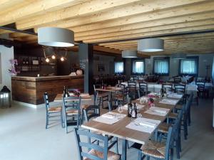 维罗纳Agriturismo Corte Maccini的餐厅设有木制天花板和桌椅