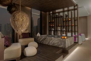 多哈Dusit Doha Hotel的带浴缸和椅子的浴室的 ⁇ 染
