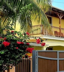 路易港Casa Accacias的一个带围栏和红色鲜花阳台的房子