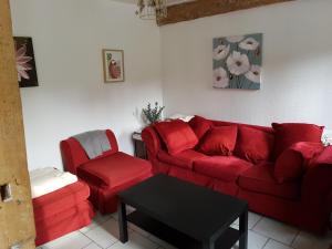 GueuresLes Gites de la Renardière的客厅配有红色的沙发和椅子